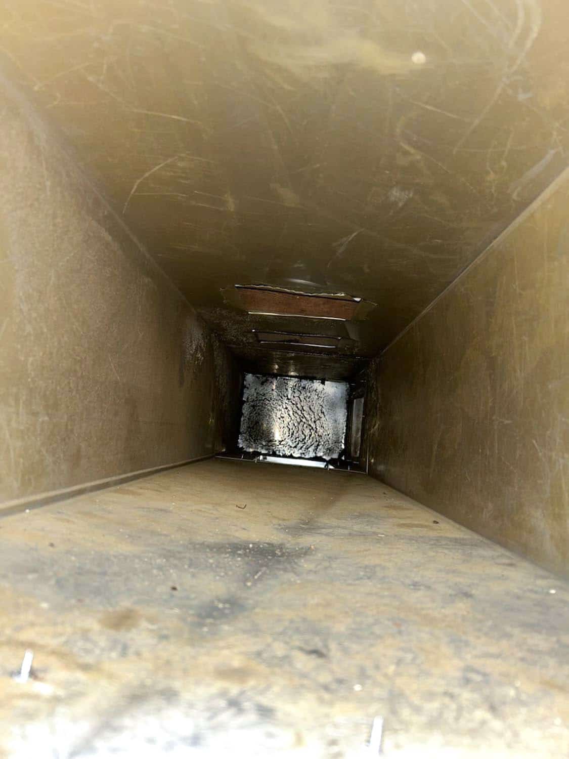 Interior view of a dirty air duct showing dust accumulation and debris, highlighting the need for professional duct cleaning services by 800 Duct.