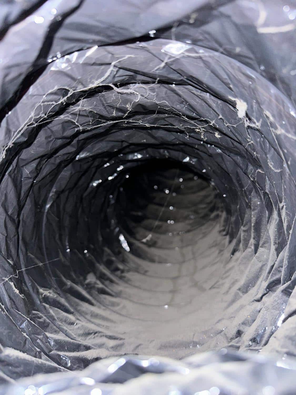 Close-up view of a dirty air duct interior, showcasing dust accumulation and debris, highlighting the need for professional duct cleaning services by 800 Duct.